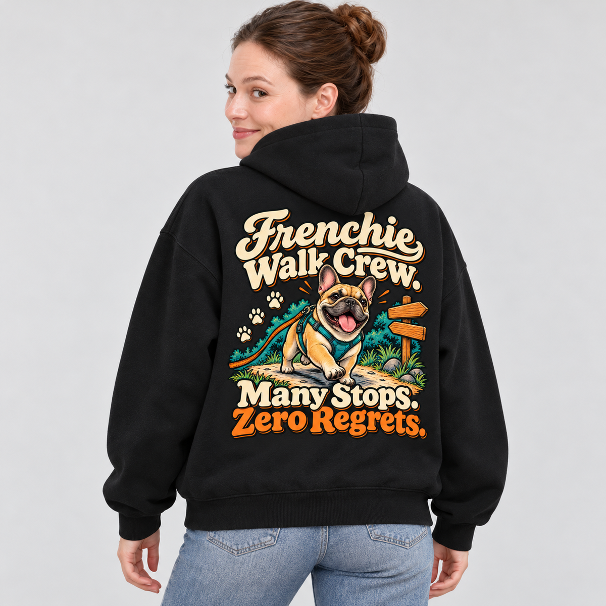 Woman wearing a black French Bulldog hoodie with the Frenchie Walk Crew. Many Stops. Zero Regrets back print.