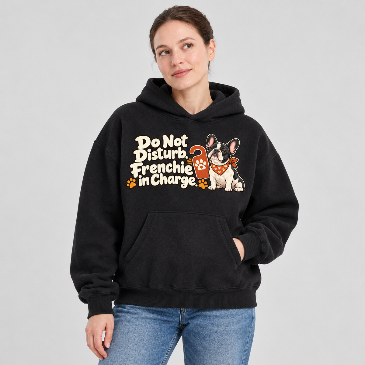 Woman wearing a black French Bulldog hoodie with the Do Not Disturb. Frenchie in Charge front print.