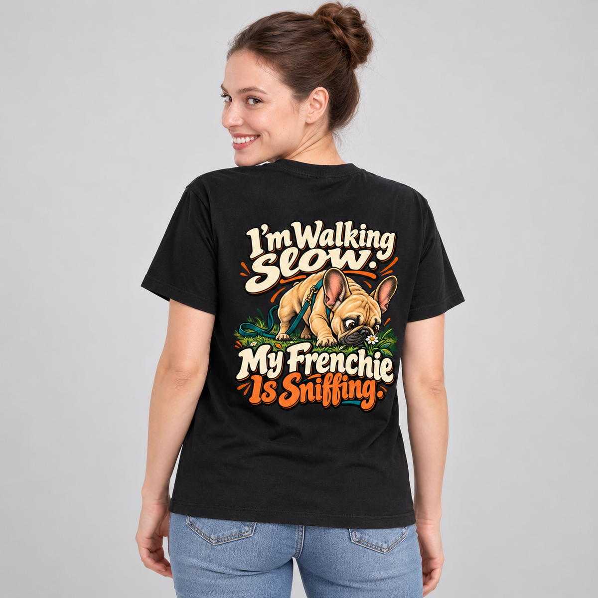 Close-up of I'm Walking Slow. My Frenchie Is Sniffing. artwork on the back of a black cotton T-shirt