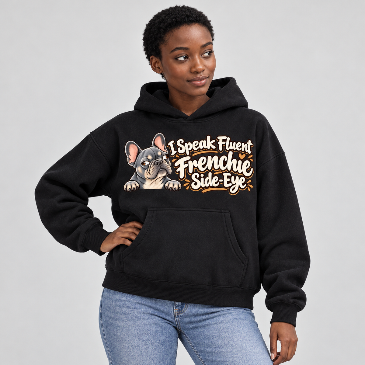Woman wearing a black French Bulldog hoodie with the I Speak Fluent Frenchie Side-Eye front print.