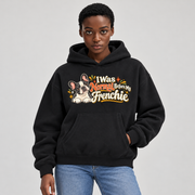 Woman wearing a black French Bulldog hoodie with the I Was Normal Before My Frenchie front print.