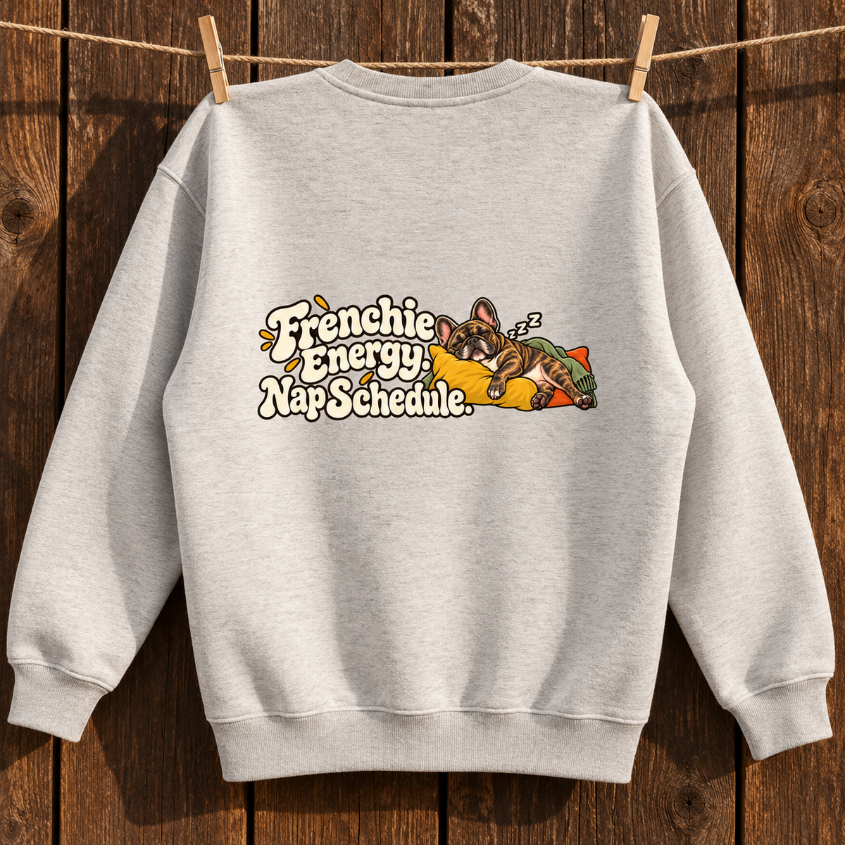 Close-up of Frenchie Energy. Nap Schedule. back artwork on a oat gray fleece sweatshirt