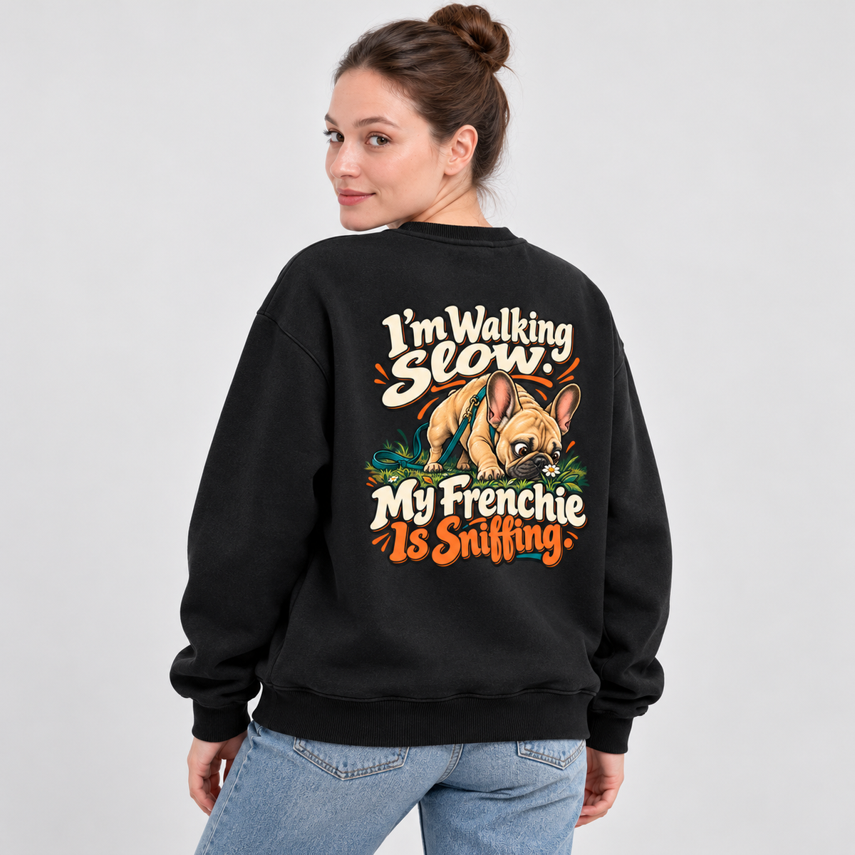 Model wearing a black French Bulldog sweatshirt with I'm Walking Slow. My Frenchie Is Sniffing. on the back