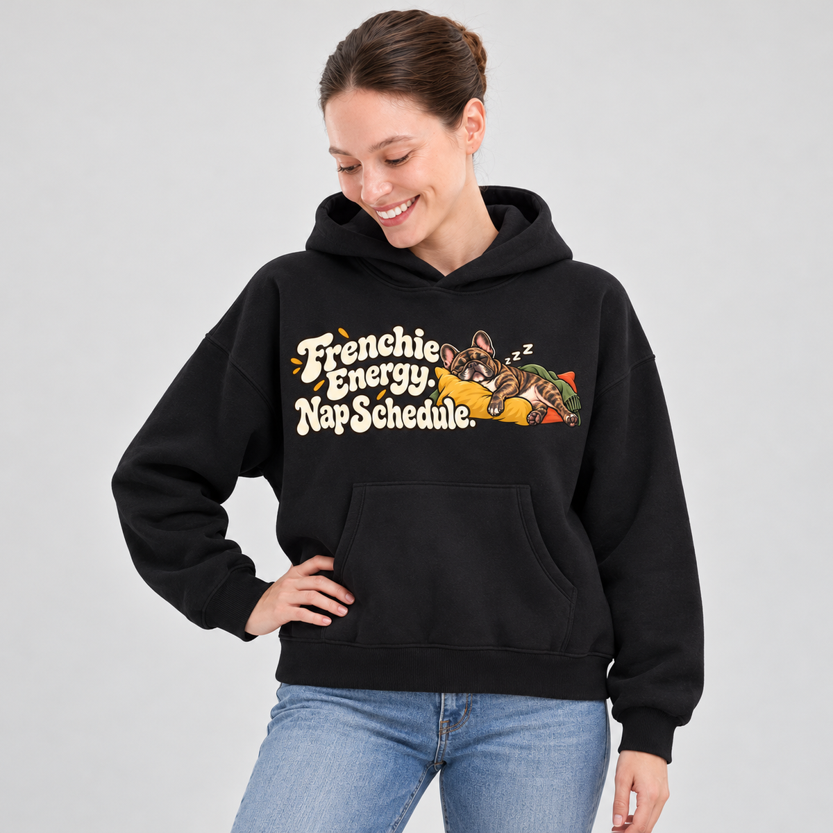 Woman wearing a black French Bulldog hoodie with the Frenchie Energy. Nap Schedule front print.